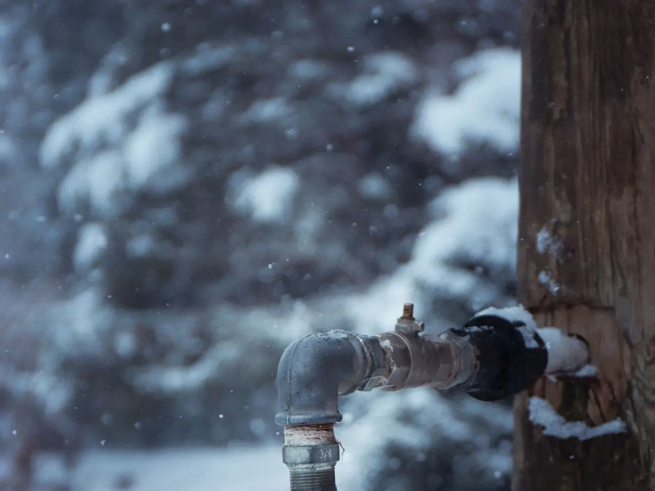 Outdoor water tap dripping in a snowy winter yard